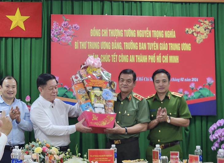 Trưởng Ban Tuyên giáo Trung ương Nguyễn Trọng Nghĩa (thứ hai từ trái) trao quà Tết cho Giám đốc Công an TP.HCM Lê Hồng Nam - Ảnh: CẨM NƯƠNG
