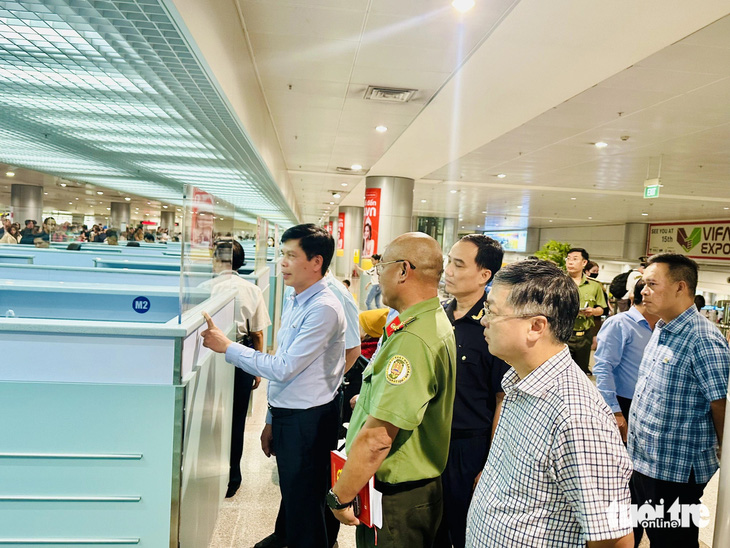 Thứ trưởng Bộ Giao thông vận tải Lê Anh Tuấn (áo xanh đứng phía trước) giám sát công tác phối hợp giữa các bên ở khâu nhập cảnh tại ga quốc tế Tân Sơn Nhất chiều 3-2 (24 tháng chạp) - Ảnh: CÔNG TRUNG