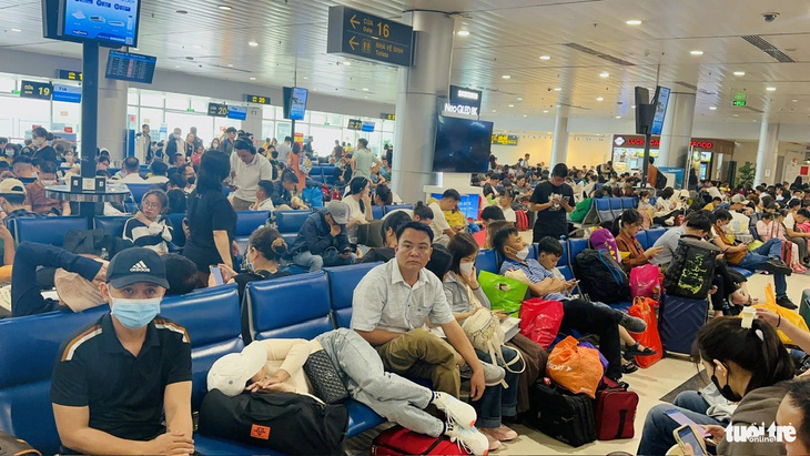 Hành khách ngồi chờ chuyến bay đông nghẹt người tại sảnh ra máy bay. Nguyên nhân nhiều chuyến bị hoãn (delay) từ 1-5 tiếng khiến nhà ga nội địa ùn ứ - Ảnh: CÔNG TRUNG