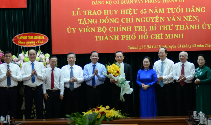 Ban Thường vụ Thành ủy TP.HCM trao hoa chúc mừng Bí thư Thành ủy Nguyễn Văn Nên - Ảnh: TIẾN LONG