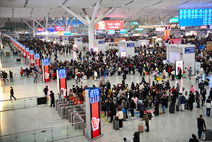 Hành khách xếp hàng chờ kiểm tra vé tại nhà ga Thâm Quyến, Trung Quốc hôm 26-1 - Ảnh: TÂN HOA XÃ