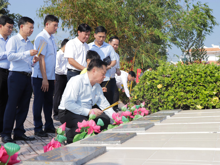 Ông Nguyễn Trọng Nghĩa thắp hương cho liệt sĩ tại nghĩa trang huyện Gò Công Đông - Ảnh: CẨM NƯƠNG 