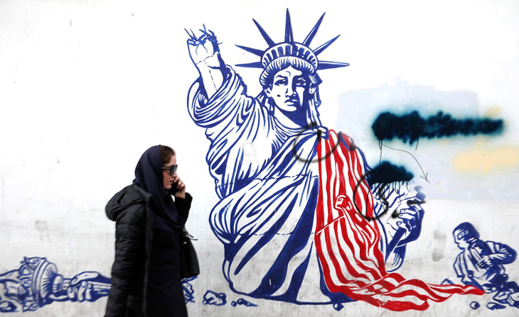 Một người phụ nữ đi ngang qua tranh vẽ graffiti chống Mỹ bên ngoài tòa nhà trước đây là nơi đặt Đại sứquán Mỹ ở Tehran vào hôm 30-1 - Ảnh AFP