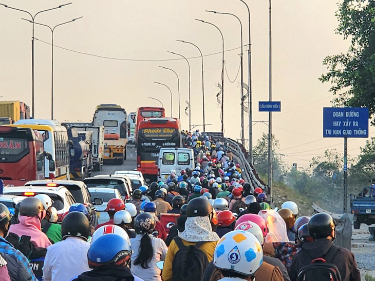 Đông nghịt xe máy, ô tô nối đuôi nhau di chuyển chậm qua cầu Bình Điền (huyện Bình Chánh) vào khoảng 17h20 ngày 3-2 - Ảnh: NGỌC KHẢI