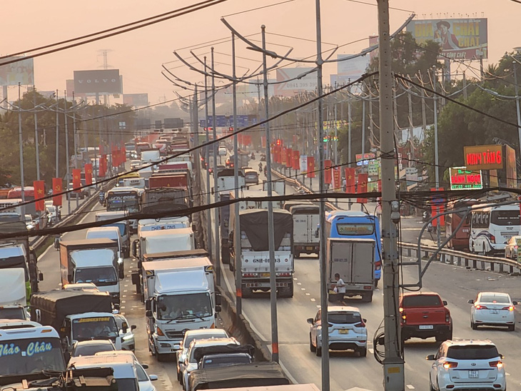 Ô tô các loại nối đuôi nhau dồn ứ, di chuyển chậm tại đường dẫn Bình Thuận - Chợ Đệm hướng từ Long An đi TP.HCM (đoạn gần cầu vượt nút giao Bình Thuận) vào khoảng 17h30 ngày 3-2 - Ảnh: NGỌC KHẢI