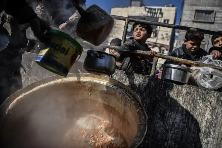 Những đứa trẻ Palestine xin thức ăn tại một điểm phân phát thực phẩm ở thành phố Rafah, phía nam Dải Gaza ngày 1-2. Israel đang đẩy cuộc chiến ở Gaza xa hơn về phía nam, gần biên giới Ai Cập, sau khi tuyên bố đã giải tán lữ đoàn Hamas ở Khan Younis - Ảnh: GETTY