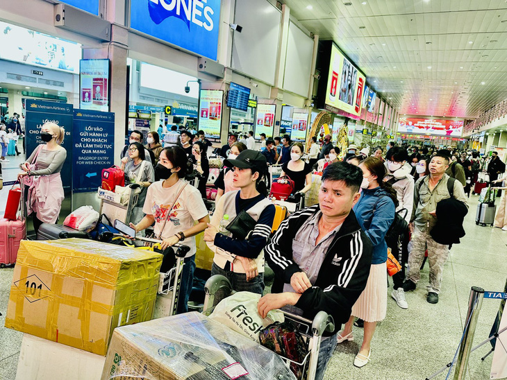 Hành khách xếp hàng dài chờ vào làm thủ tục check-in trong vài ngày gần đây tại sân bay Tân Sơn Nhất - Ảnh: CÔNG TRUNG