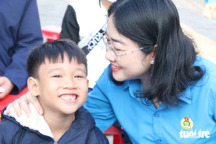 Một em nhỏ  vui cười khi được bà Nguyễn Kim Loan - chủ tịch Liên đoàn Lao động tỉnh Bình Dương - hỏi thăm trước khi lên tàu về quê đón Tết cùng gia đình - Ảnh: H.TRUNG