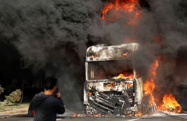 Một chiếc xe tải bốc cháy sau khi cháy rừng lan rộng ở Vina del Mar, Chile - Ảnh: REUTERS