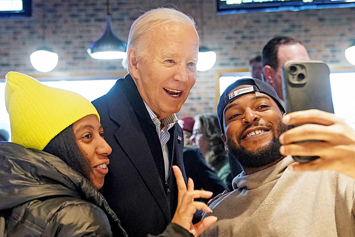 Tổng thống Mỹ Joe Biden chụp ảnh cùng hai người da màu khi đến thăm Michigan vào ngày 2-2 - Ảnh: Reuters