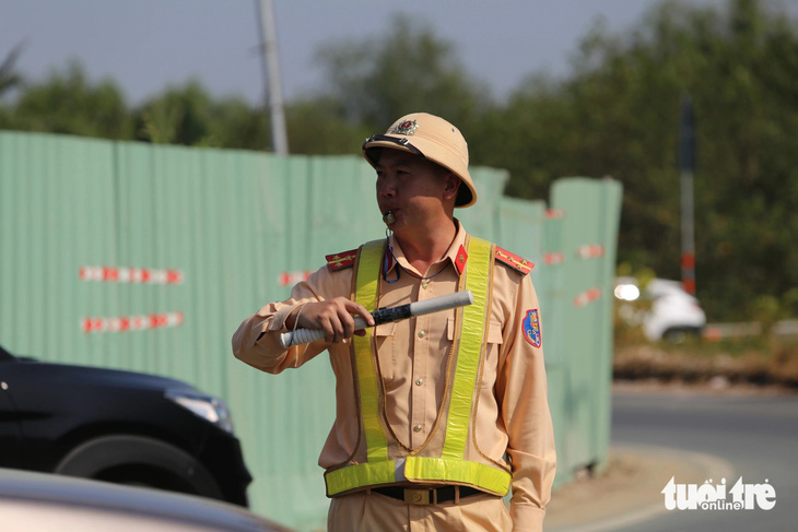 Lực lượng Cục Cảnh sát giao thông phân luồng xe vào cao tốc TP.HCM - Long Thành - Dầu Giây ngày 4-2 - Ảnh: MINH HÒA
