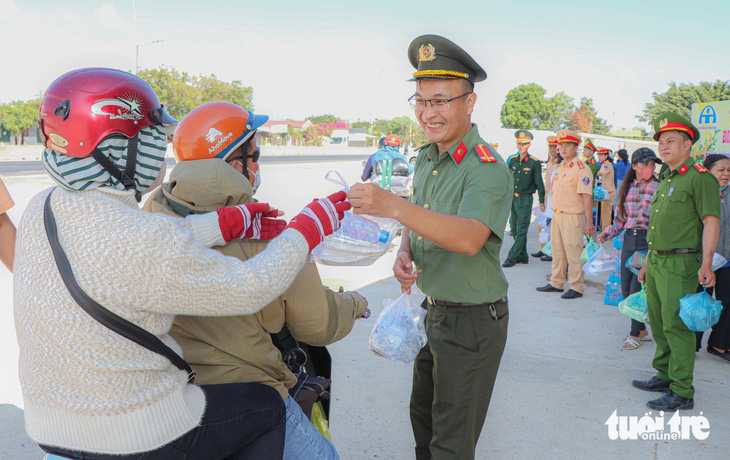 Trên đường về quê đón Tết, người dân bất ngờ được bộ đội, công an, đoàn viên thanh niên, phụ nữ... huyện Thuận Nam mời vào tặng quà - Ảnh: DUY NGỌC