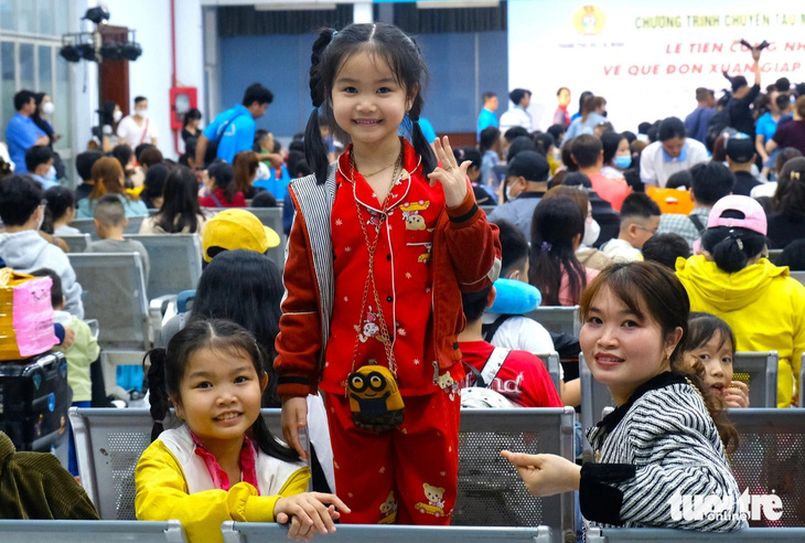 Hai chị em Mỹ Tuyền, Phương Nghi (quê Thừa Thiên Huế) háo hức khi lần đầu tiên đến ga Sài Gòn đi tàu với cha mẹ về quê ăn Tết. Chị Nguyễn Thị Mùi - mẹ của hai bé - đã làm việc tại Công ty Paiho (quận Bình Tân) 9 năm - Ảnh: VŨ THỦY