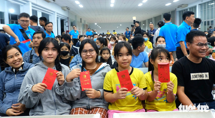 4 người con của chị Lê Thị Hiền (41 tuổi, quê Thừa Thiên Huế) với niềm vui nhận lì xì từ Liên đoàn Lao động TP.HCM trước khi theo cha mẹ lên tàu về quê ăn Tết. Chị Huyền đã 15 năm làm công nhân tại TP.HCM - Ảnh: VŨ THỦY