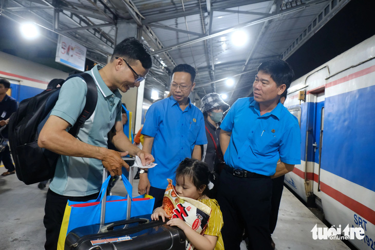 Lãnh đạo Liên đoàn Lao động TP.HCM đến tiễn gia đình công nhân về quê ăn Tết tại ga Sài Gòn tối 4-2 - Ảnh: VŨ THỦY