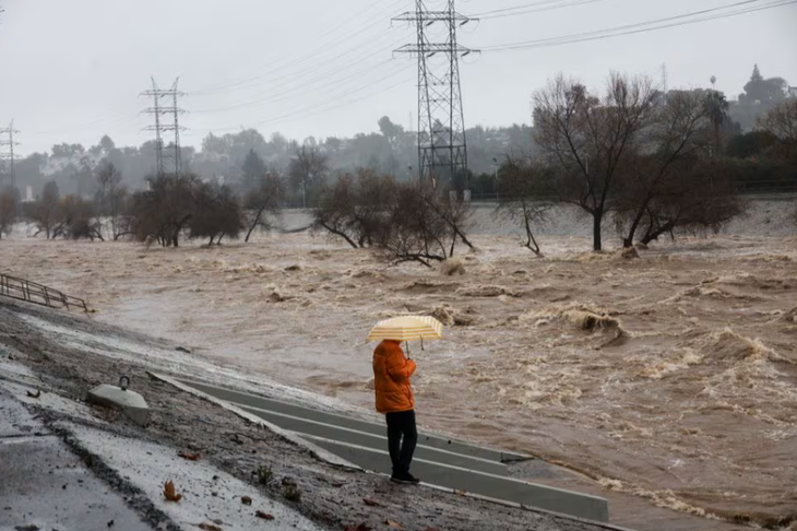 Một người dân chứng kiến lũ lụt nhấn chìm khu vực xung quanh thành phố Los Angeles, ảnh chụp vào ngày 5-2 - Ảnh: REUTERS