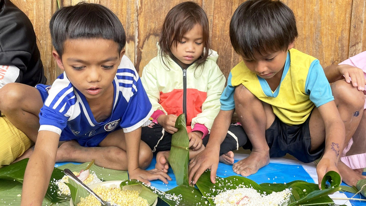 Những đứa trẻ ở vùng núi Quảng Nam lần đầu tiên được dạy và mày mò tự gói bánh chưng - Ảnh: BÌNH NAM