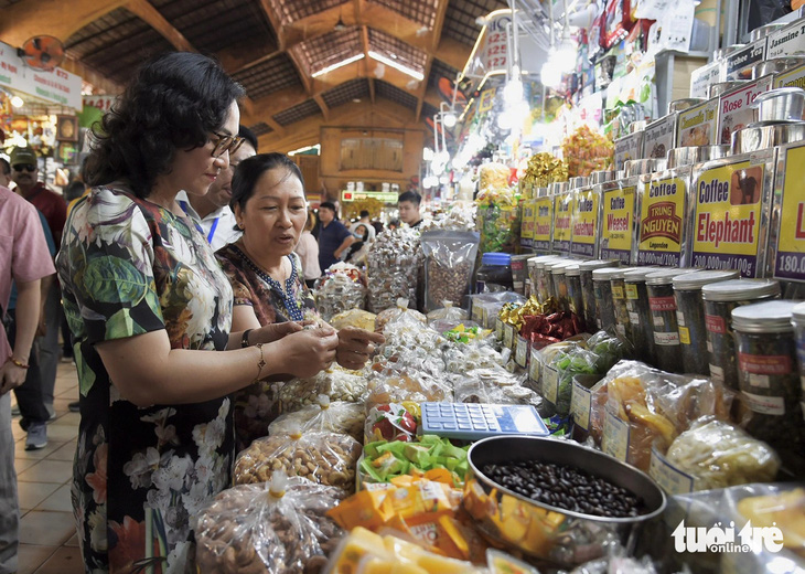 Thứ trưởng Bộ Công Thương tìm hiểu về các sản phẩm quầy mứt, bánh kẹo... là mặt hàng bán chạy nhất tại chợ Bến Thành hiện nay - Ảnh: TỰ TRUNG
