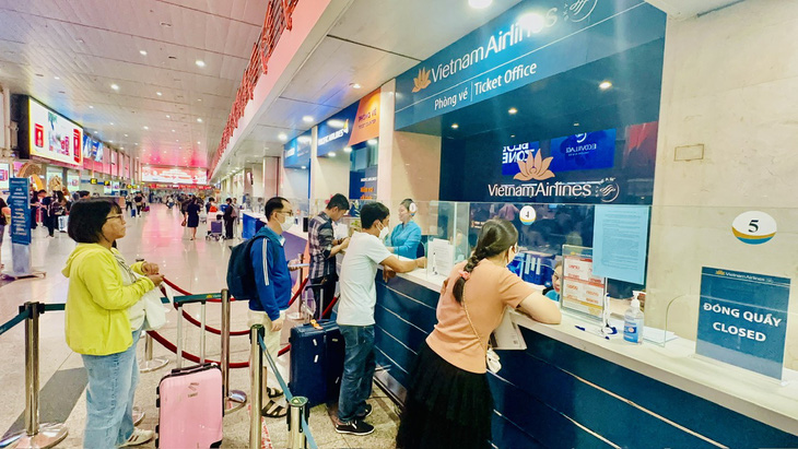 Hành khách mua vé máy bay hoặc đợi tư vấn tình trạng vé tại quầy Vietnam Airlines trong dịp Tết - Ảnh: CÔNG TRUNG