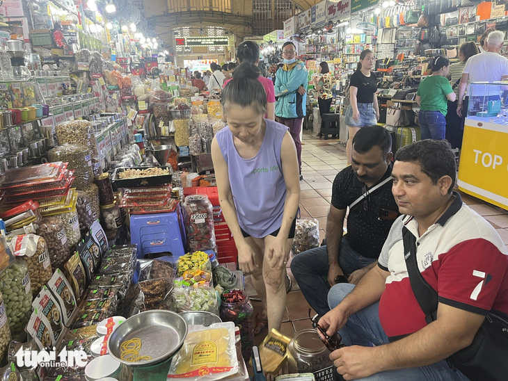 Khách quốc tế mua sắm tại chợ Bến Thành (Q.1). Anh Ravi Sachdev đến từ New Delhi, Ấn Độ cho biết thích không khí mua bán của người Việt những ngày này - Ảnh: N.BÌNH
