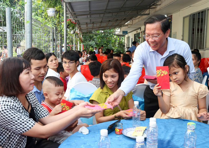Chủ tịch UBND TP.HCM Phan Văn Mãi tặng lì xì cho công nhân và con em - Ảnh: THẢO LÊ 