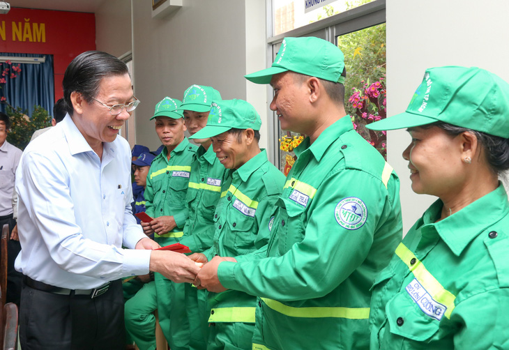 Chủ tịch UBND TP.HCM Phan Văn Mãi thăm hỏi, lì xì động viên anh Lưu Tiến Phát - Ảnh: THẢO LÊ 