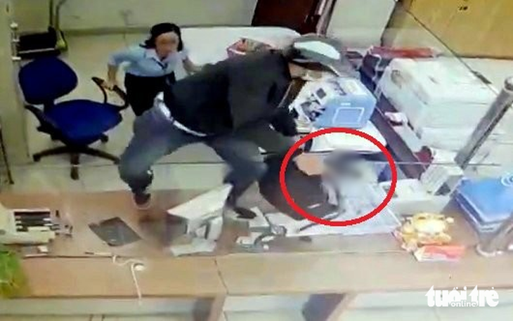 Tên cướp dùng súng uy hiếp nhân viên ngân hàng Vietinbank - Ảnh: T.A