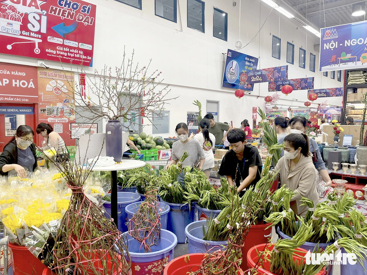 Khách vào siêu thị mua hoa ngày 29 Tết do giá cả ở đây ổn định, không tăng mạnh như chợ truyền thống - Ảnh: N.BÌNH