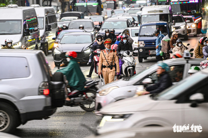 Cảnh sát giao thông phân luồng xe rời khỏi Hà Nội để nghỉ Tết - Ảnh: HỒNG QUANG