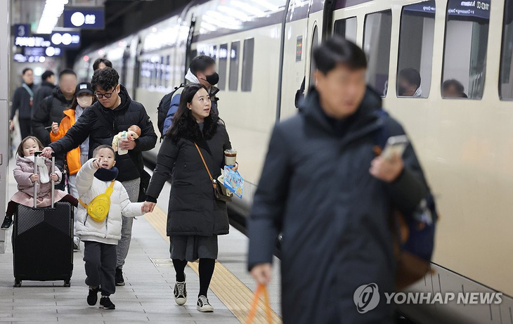 Một gia đình tại nhà ga tàu lửa tốc hành (SRT) Suseo, thủ đô Seoul sáng 8-2 - Ảnh: YONHAP