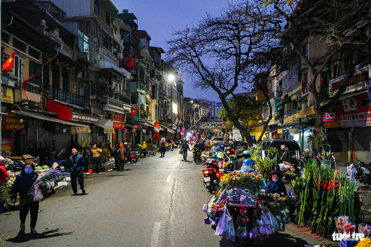 Từ sớm, phiên chợ trước cổng chợ Đồng Xuân đã ken đặc các gánh hàng - Ảnh: HỒNG QUANG