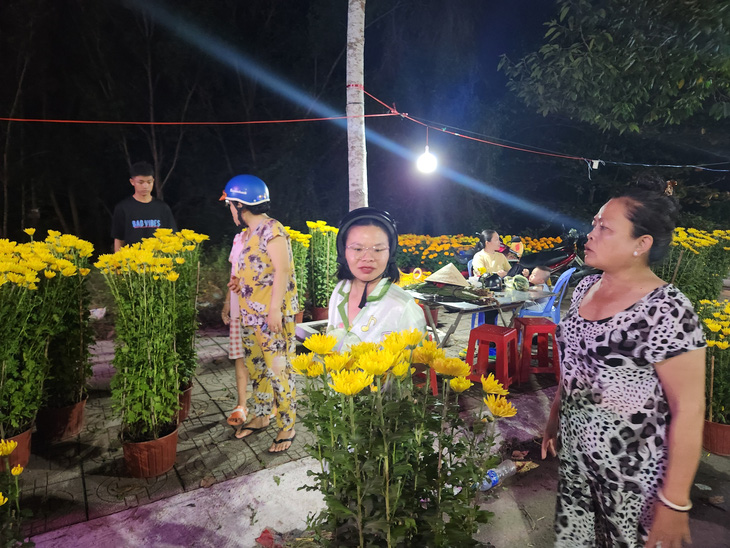 Gia đình bà Tùng đã chấp nhận lỗ 60.000 đồng/cặp hoa cúc để bán cho khách với giá 100.000 đồng/cặp - Ảnh: BỬU ĐẤU
