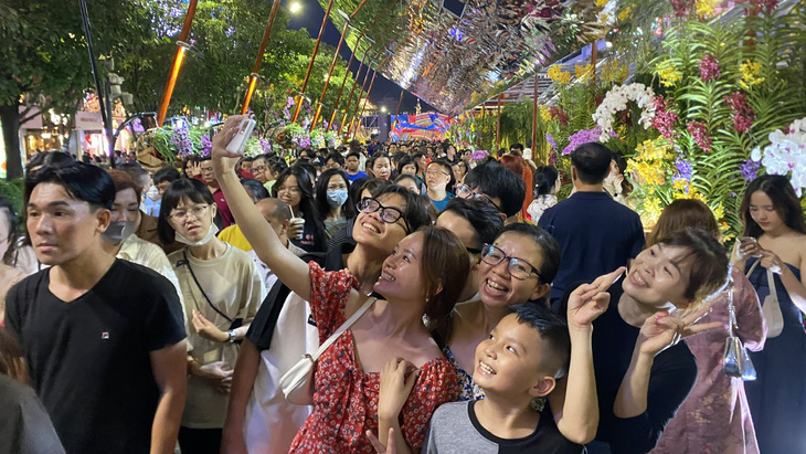 Một gia đình tham quan, chụp hình lưu niệm đường hoa Nguyễn Huệ TP.HCM - Ảnh: TỰ TRUNG
