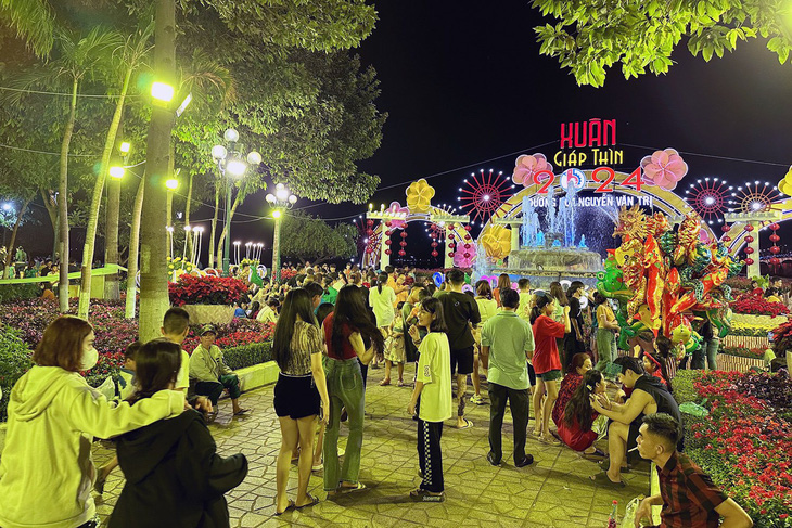 Người dân vui chơi tại đường hoa Nguyễn Văn Trị (TP Biên Hòa, Đồng Nai) chờ đón giao thừa, xem bắn pháo hoa - Ảnh: A LỘC