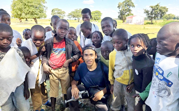 Lại Ngứa Chân bên cạnh các trẻ em ở Angola - Ảnh: NVCC