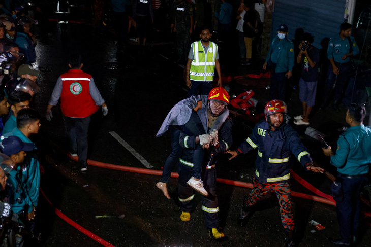 Lực lượng cứu hỏa vác một nạn nhân trong vụ cháy kinh hoàng ở Bangladesh ngày 29-2 - Ảnh: REUTERS
