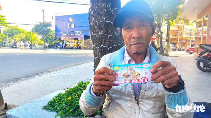 Ông Bùi Văn Tranh (62 tuổi) đang cầm trên tay tờ vé số giả mà kẻ gian đã dán đè số 2 vào số 8 - Ảnh: NGUYỄN HOÀNG