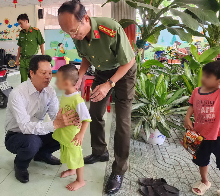 Ông Nguyễn Thành Diệu (áo trắng) - phó chủ tịch UBDND tỉnh Tiền Giang, cùng đại tá Nguyễn Văn Nhựt - giám đốc Công an tỉnh Tiền Giang, động viên các cháu bé sau vụ việc - Ảnh: HOÀI THƯƠNG