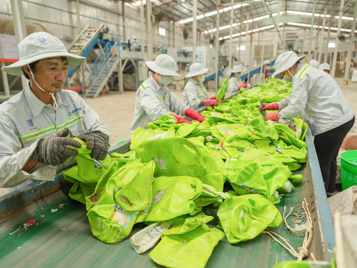 Công nhân Công ty cổ phần nhựa tái chế Duy Tân (Long An) kiểm tra, phân loại chai nhựa thải bỏ sau tiêu dùng để thực hiện tái chế - Ảnh: PHI VÂN