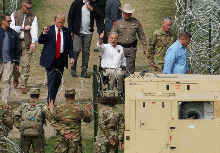 Cựu tổng thống Trump (cà vạt đỏ) thăm hàng rào biên giới Mỹ - Mexico ngày 29-2 - Ảnh: REUTERS