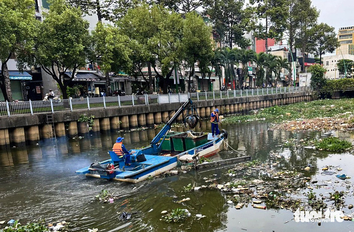 Đơn vị thu gom rác hoạt động tạm thời trở lại trên kênh Nhiêu Lộc - Thị Nghè (TP.HCM) sáng 10-3 - Ảnh: CHÂU TUẤN