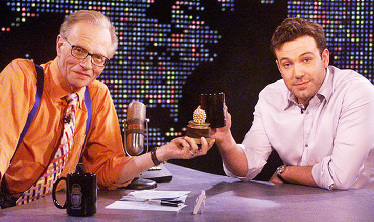 Diễn viên Ben Afleck (phải) khoe giải Mâm xôi vàng trên sóng chương trình của cố &quot;Vua truyền hình&quot; Larry King - Ảnh: GETTY IMAGES
