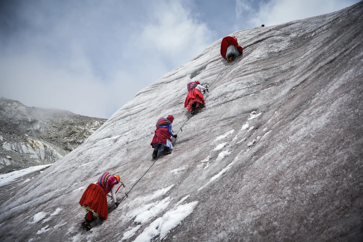 Bốn phụ nữ người bản địa đang dùng những chiếc rìu phá băng để leo lên đỉnh ngọn núi Huayna Potosi phủ đầy tuyết của Bolivia. Họ có chung mục tiêu sẽ chinh phục “nóc nhà thế giới” Everest trong năm tới - Ảnh: REUTERS