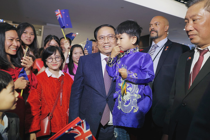 Thủ tướng Phạm Minh Chính bế một em bé trước cuộc gặp với kiều bào tại New Zealand - Ảnh: DƯƠNG GIANG