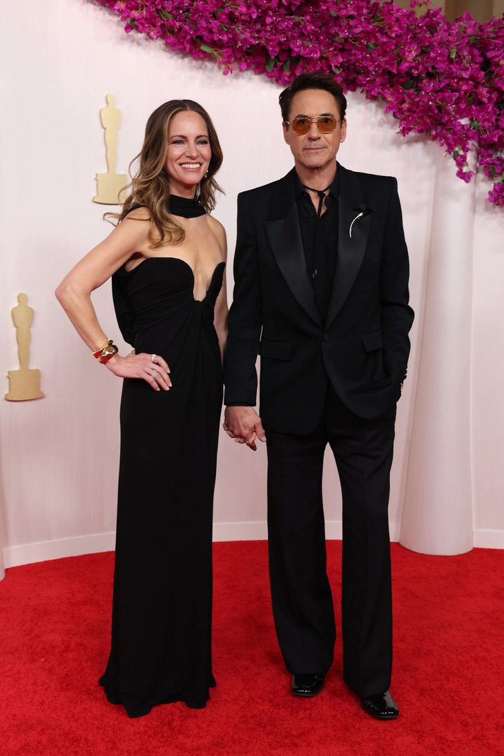 Vợ chồng tài tử Robert Downey Jr. cùng diện thiết kế của Saint Laurent. Robert Downey Jr. đã càn quét hạng mục Nam diễn viên phụ xuất sắc nhất ở hầu hết các giải thưởng hàn lâm trong năm nay, anh cũng được nhiều chuyên gia dự báo sẽ "ẵm" luôn Oscar cho hạng mục này - Ảnh: GETTY IMAGES