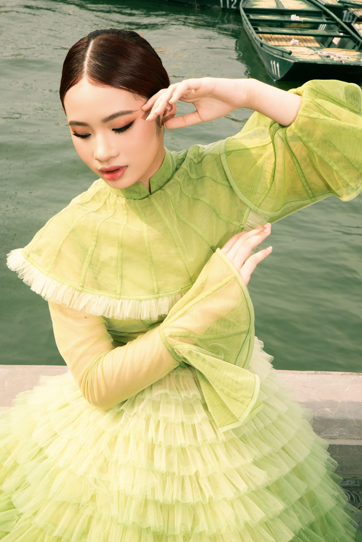 Với thiết kế thứ hai, mẫu nhí Bảo Hà đã mang đến một thiết kế hiện đại hơn với chiếc đầm bồng xòe tone xanh khi thực hiện những shoot ảnh tại hồ nước rộng mênh mông trong quần thể di tích Tam Chúc.