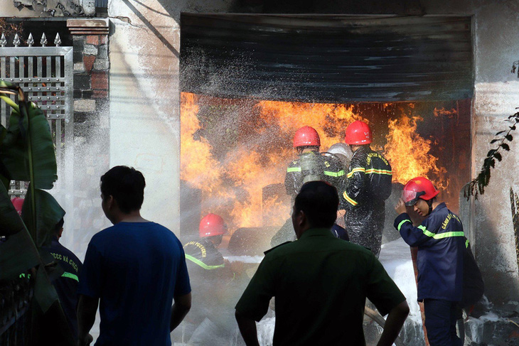 Lực lượng chức năng nỗ lực tiếp cận, dập đám cháy tại kho chứa sơn, ngăn chặn cháy lan - Ảnh: AN BÌNH
