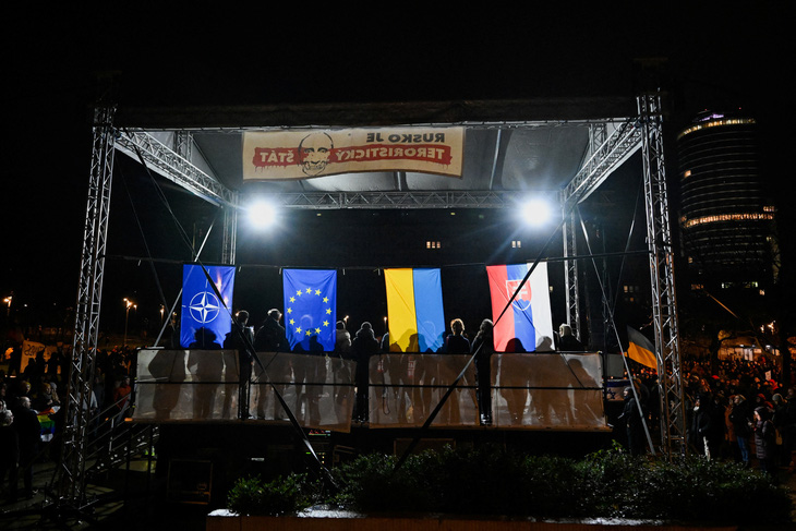 Những người tuần hành treo cờ NATO, EU, Ukraine bên cạnh cờ Slovakia - Ảnh: REUTERS