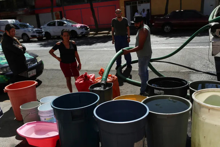 Người dân đổ đầy nước từ xe tải vào các vật chứa giữa tình trạng khan hiếm nước ở Mexico City, Mexico vào ngày 26-1 năm nay - Ảnh: REUTERS