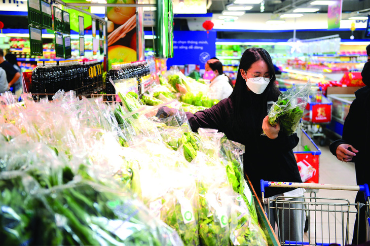 Mua rau bọc trong bao bì tự hủy tại một siêu thị ở TP.HCM. Ảnh: Quang Định